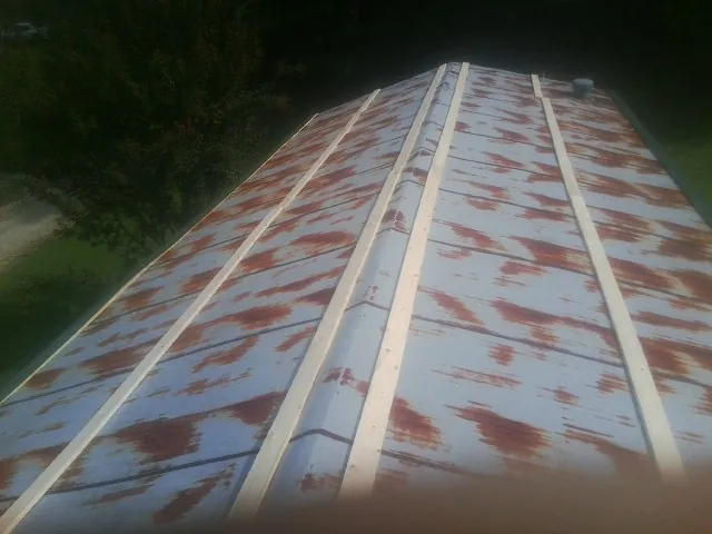 Rusted metal roof panels with new wood purlins before replacement — Storm Damage Roof Repair in Tropic by Roofing Brothers